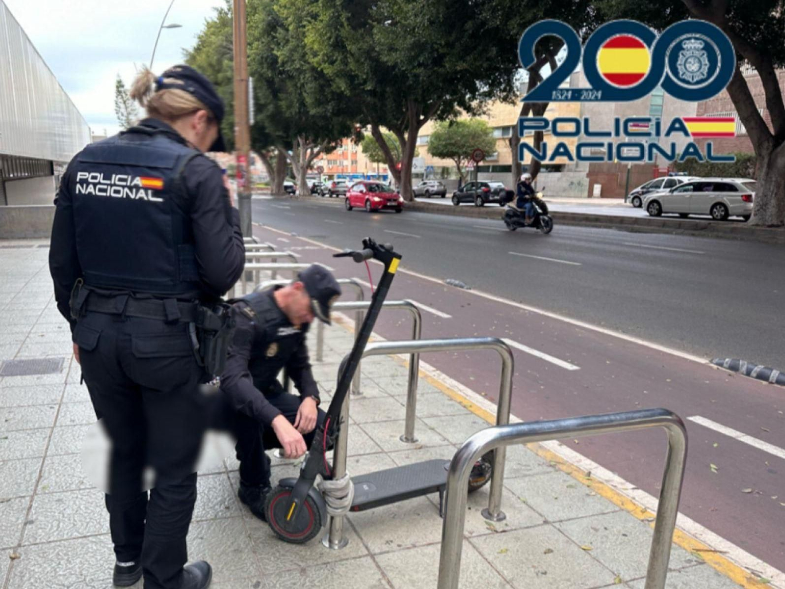 Dos agentes comprueban si es fácil robar un patinete estacionado en la calle.