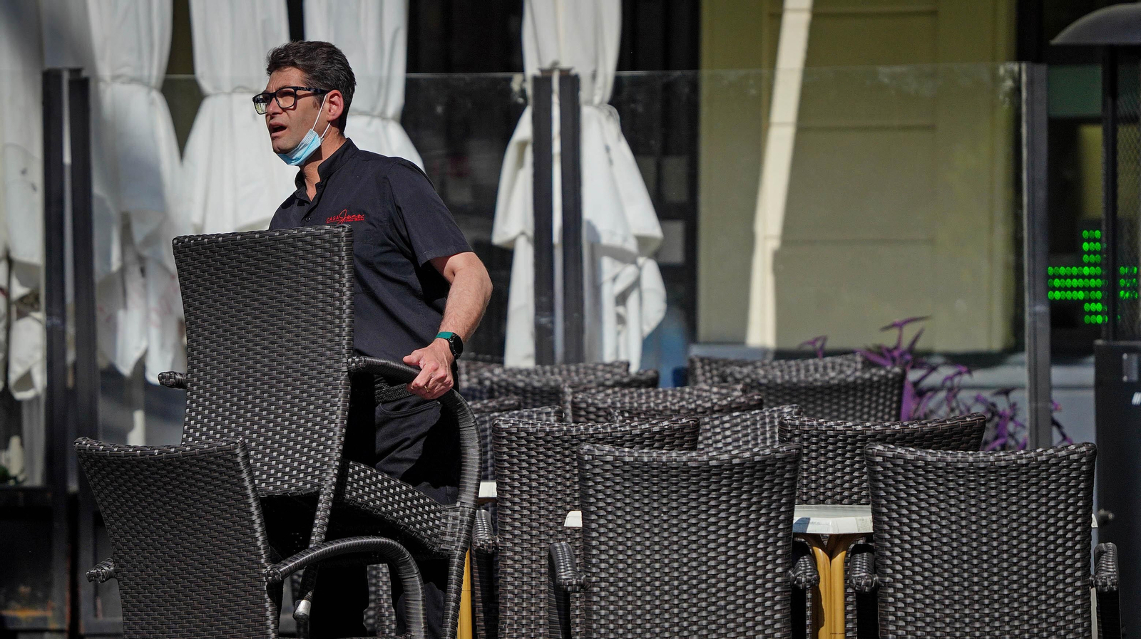 Un camarero monta la terraza de un bar del centro.