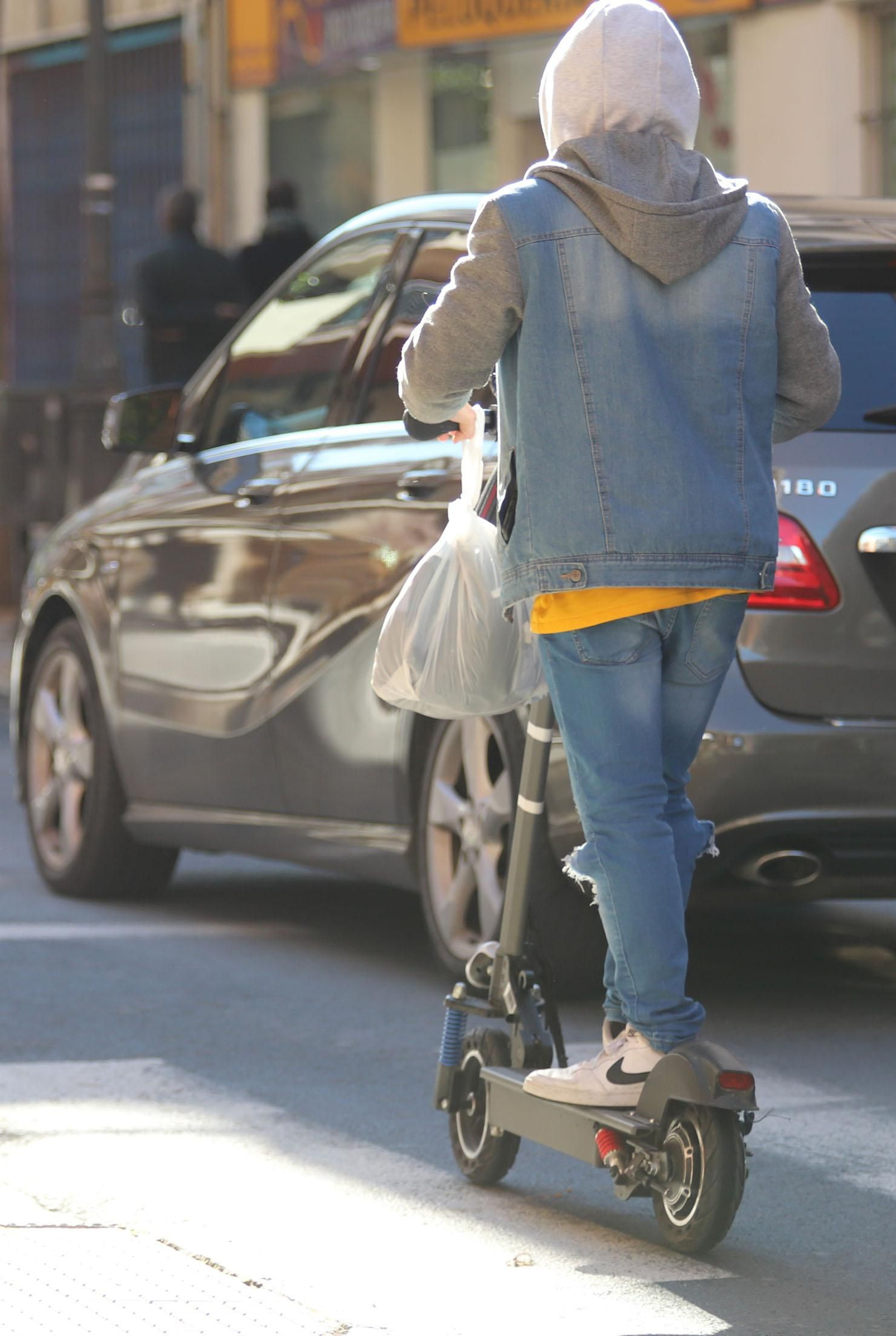 Una persona en patinete por las calles de Huelva.