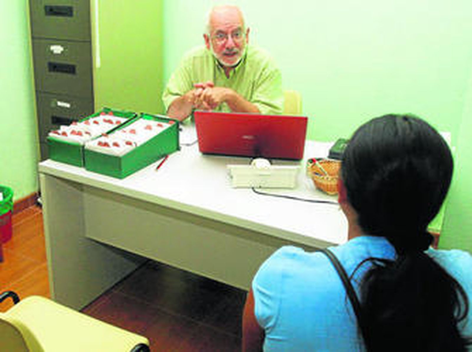 Juan Manuel Pérez Peña atiende a una inmigrante en la sede de La Línea Acoge.