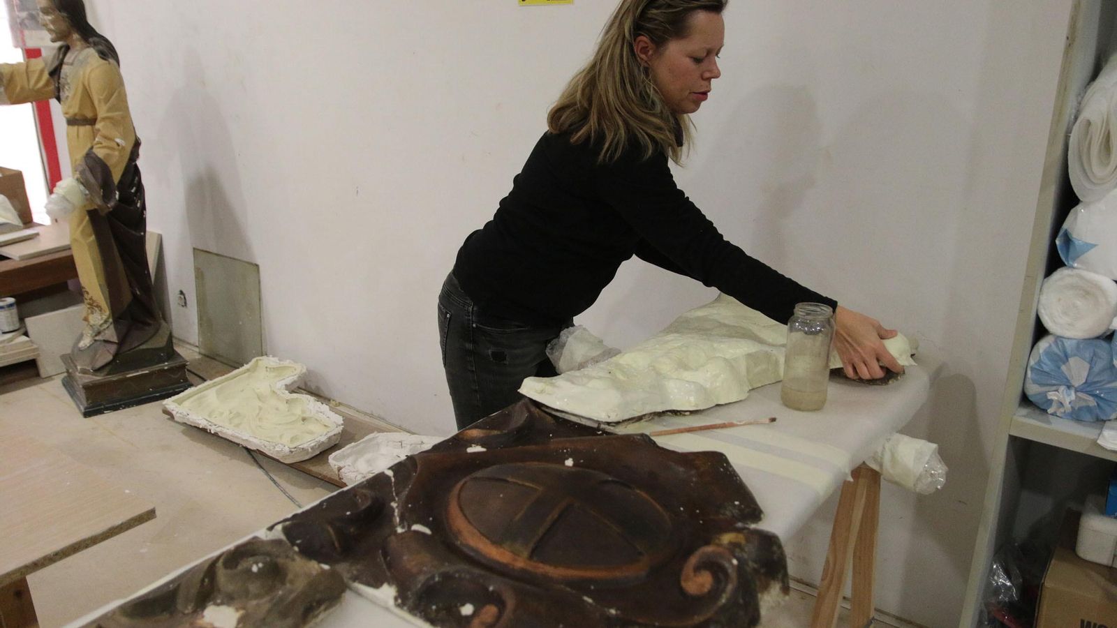 La restauradora Noemí Sánchez con los moldes de silicona empleados para recomponer las figuras mitológicas de las puertas plenarias