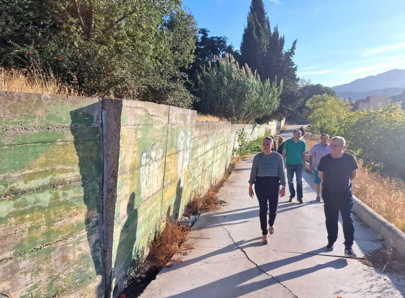 Miembros del PSOE y de la AVV observan estado del muro de Cortijo Vides.