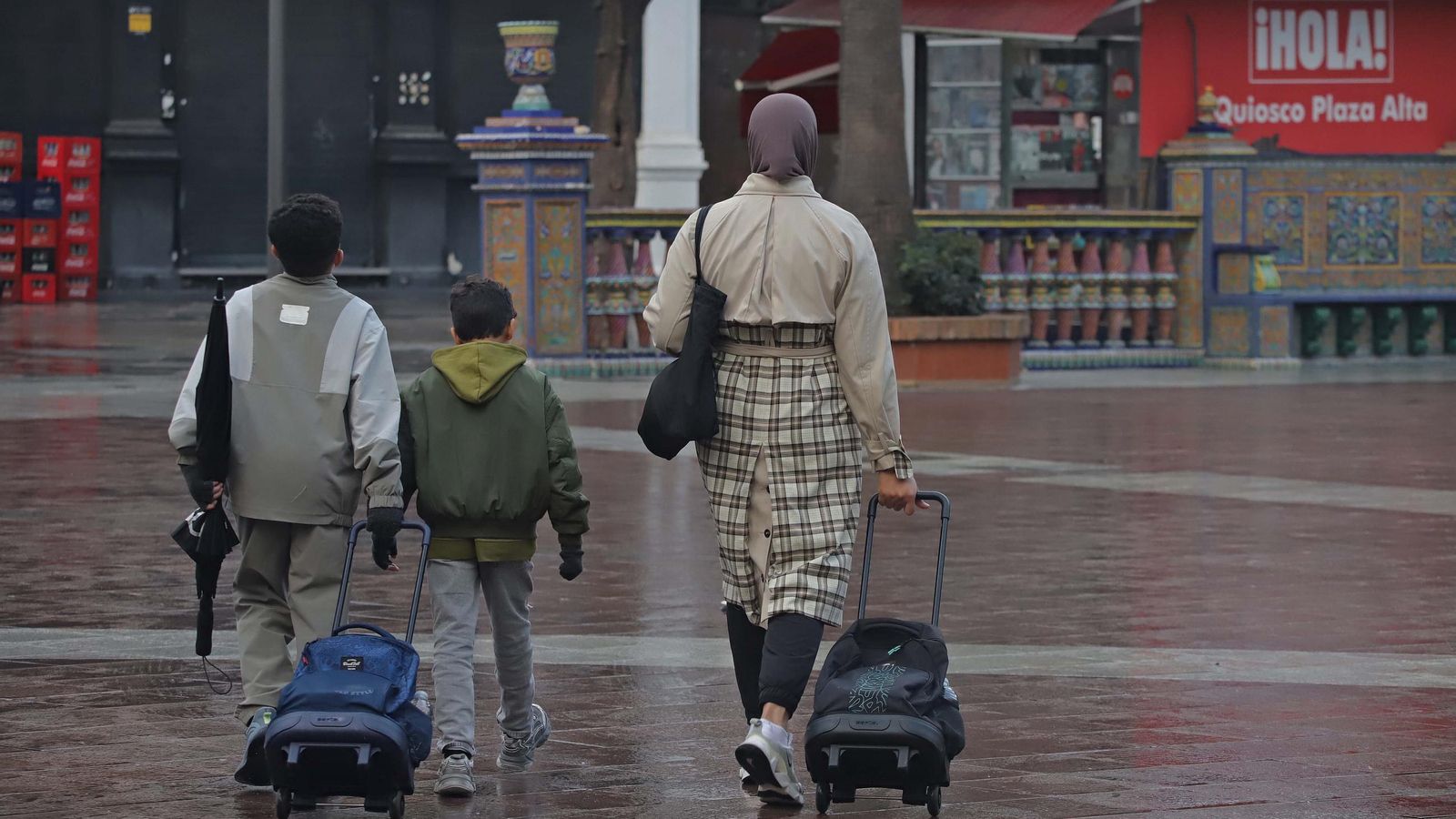 Una mujer camina junto a sus hijos por la Plaza Alta de Algeciras.