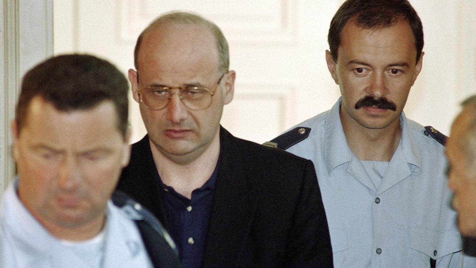 Jean-Claude Romand, escoltado por la policía antes de uno de sus juicios.