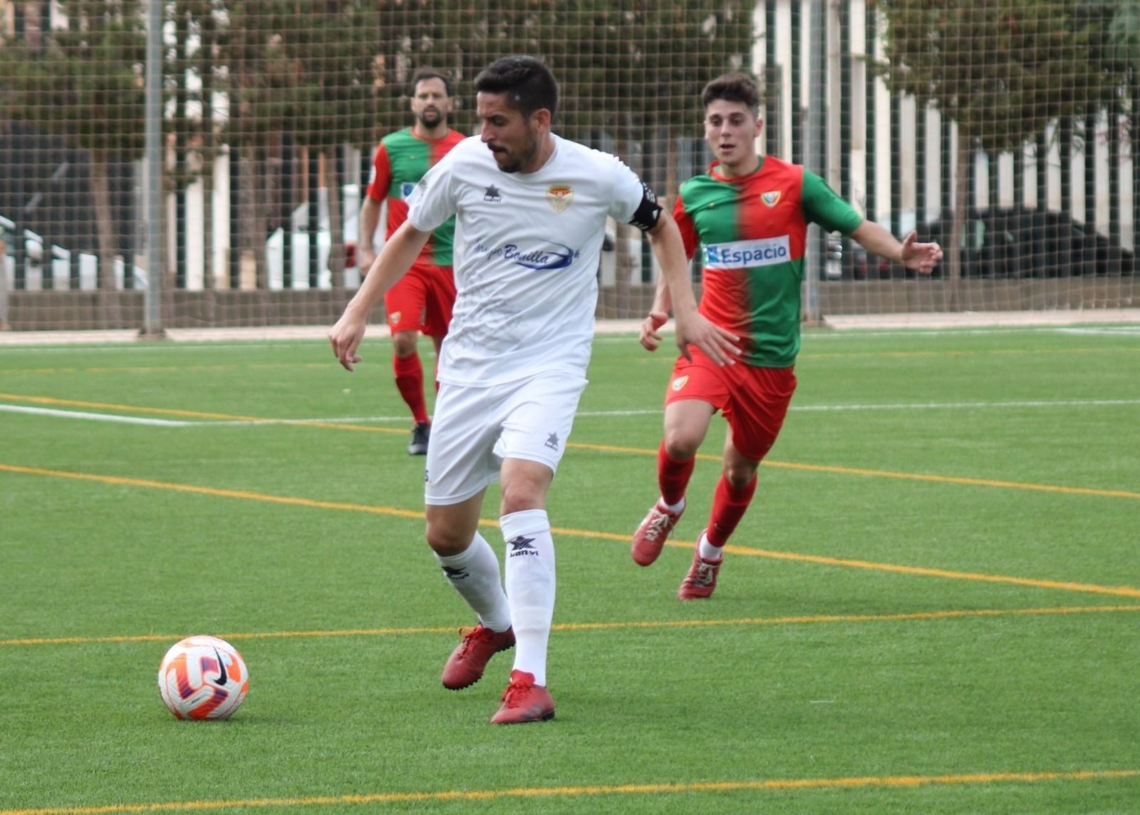 Dos jugadores arlequinados se acercan a su par del Martos, en el choque de este domingo.