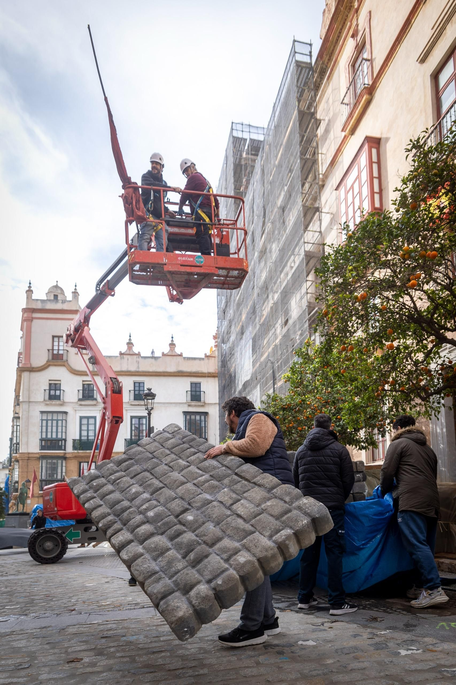 Operarios trabajando en los decorados del rodaje de 'Young Sherlock' en la plaza de Argüelles.