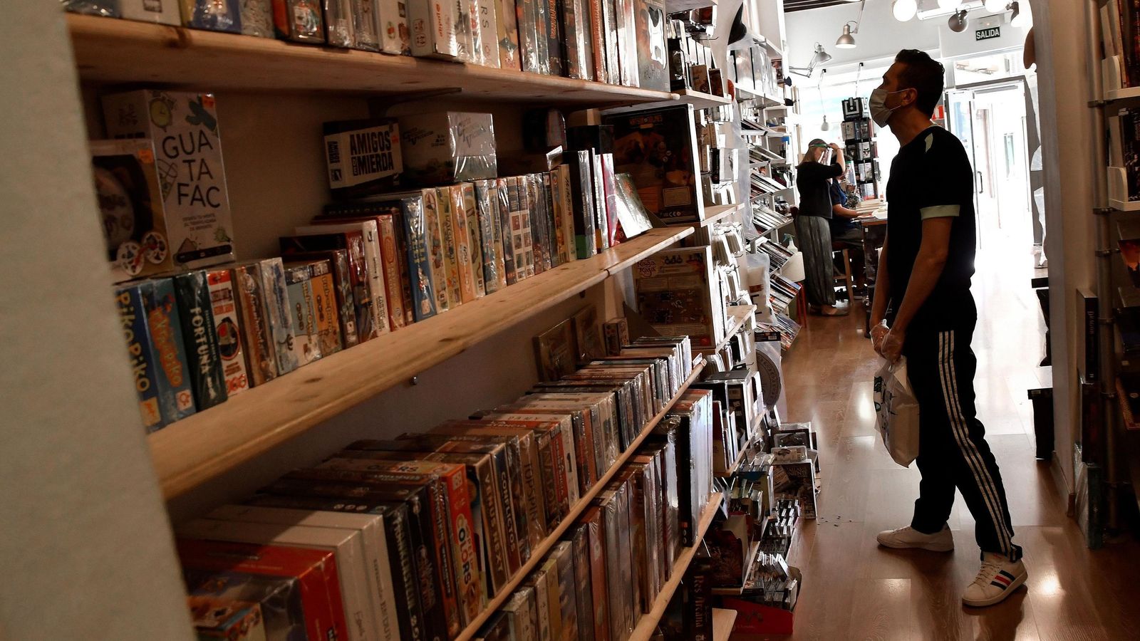 Un cliente observa diferentes juegos de mesa.