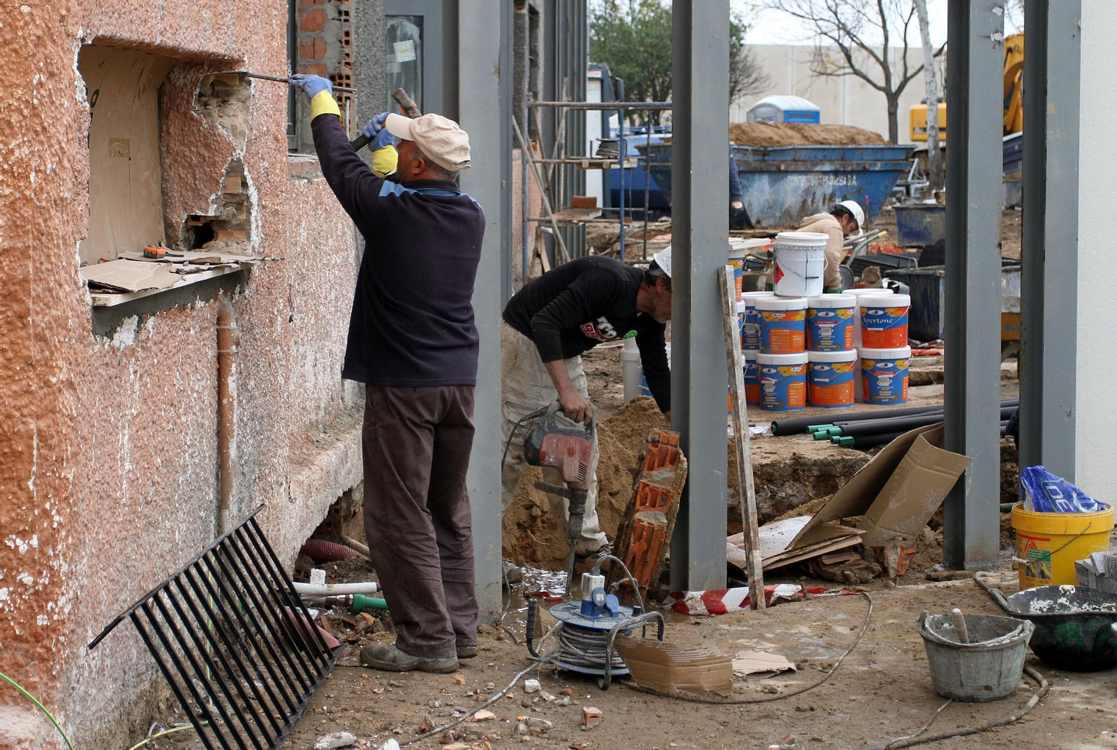 Obreros trabajando en el cambio de ventanas de una vivienda.