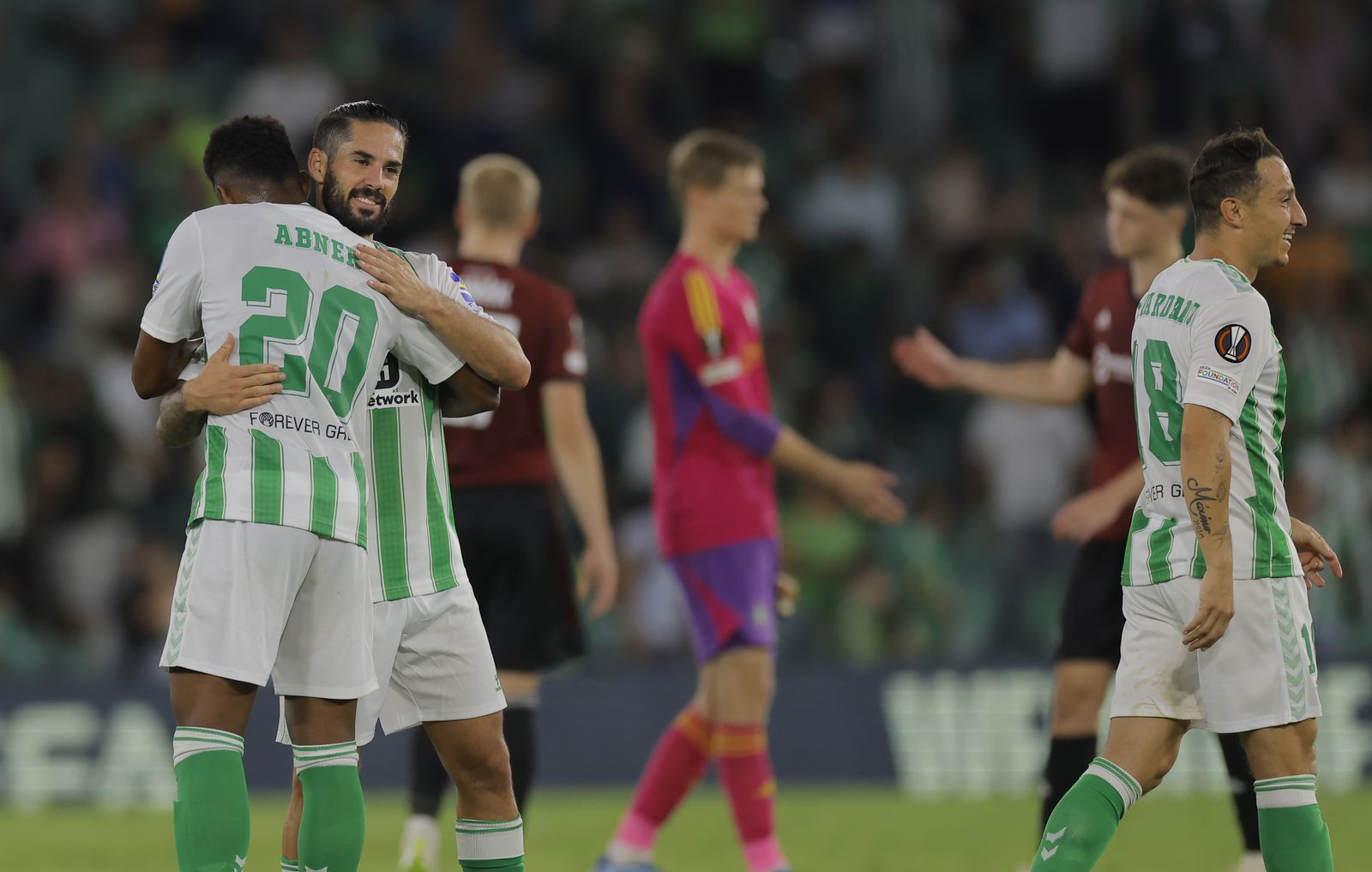 Isco es felicitado por Abner con un sonriente Guardado a la derecha.