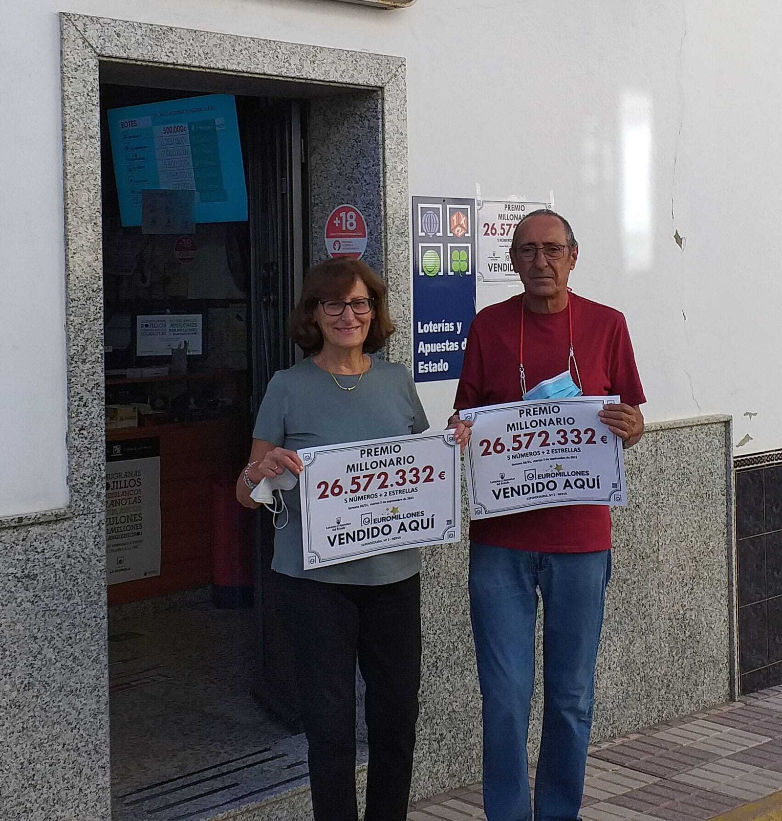 La lotera junto a la puerta de su establecimiento