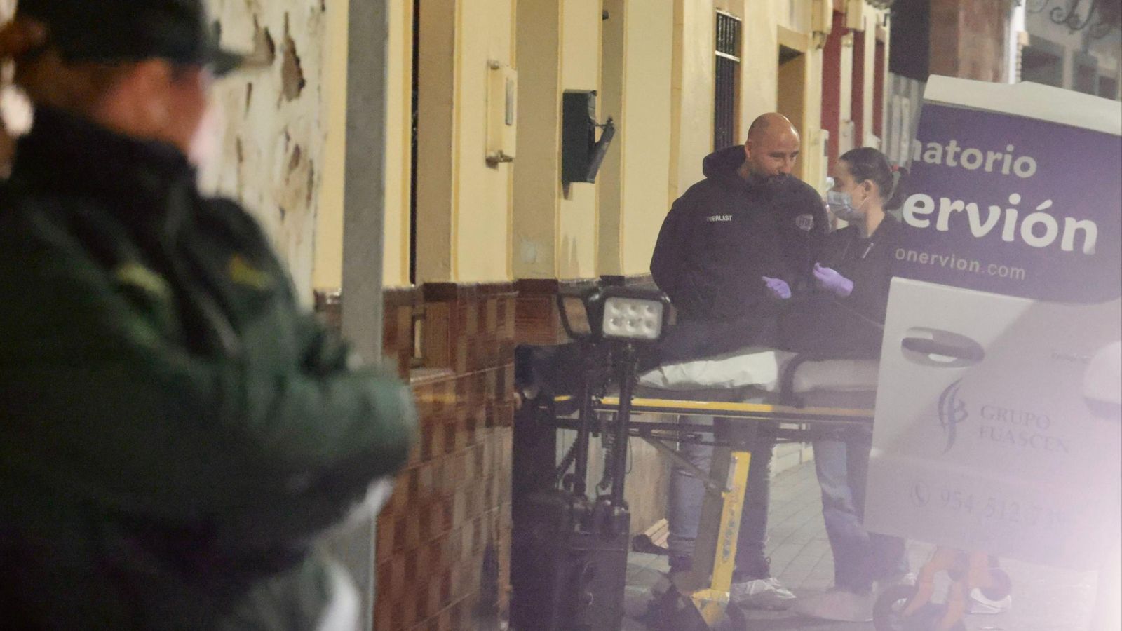 La camilla con el cuerpo de la víctima, en la puerta de la casa donde se produjo el crimen.