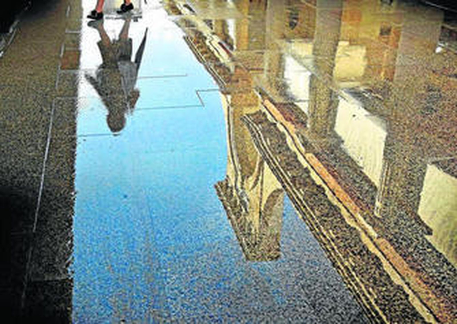 Imagen del interior del Mercado de Abastos, con el suelo mojado un día de lluvia.