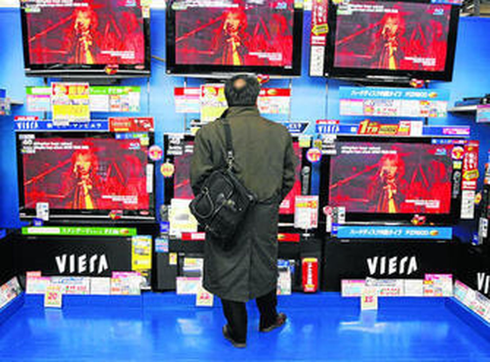 Un hombre observa distintas televisiones.