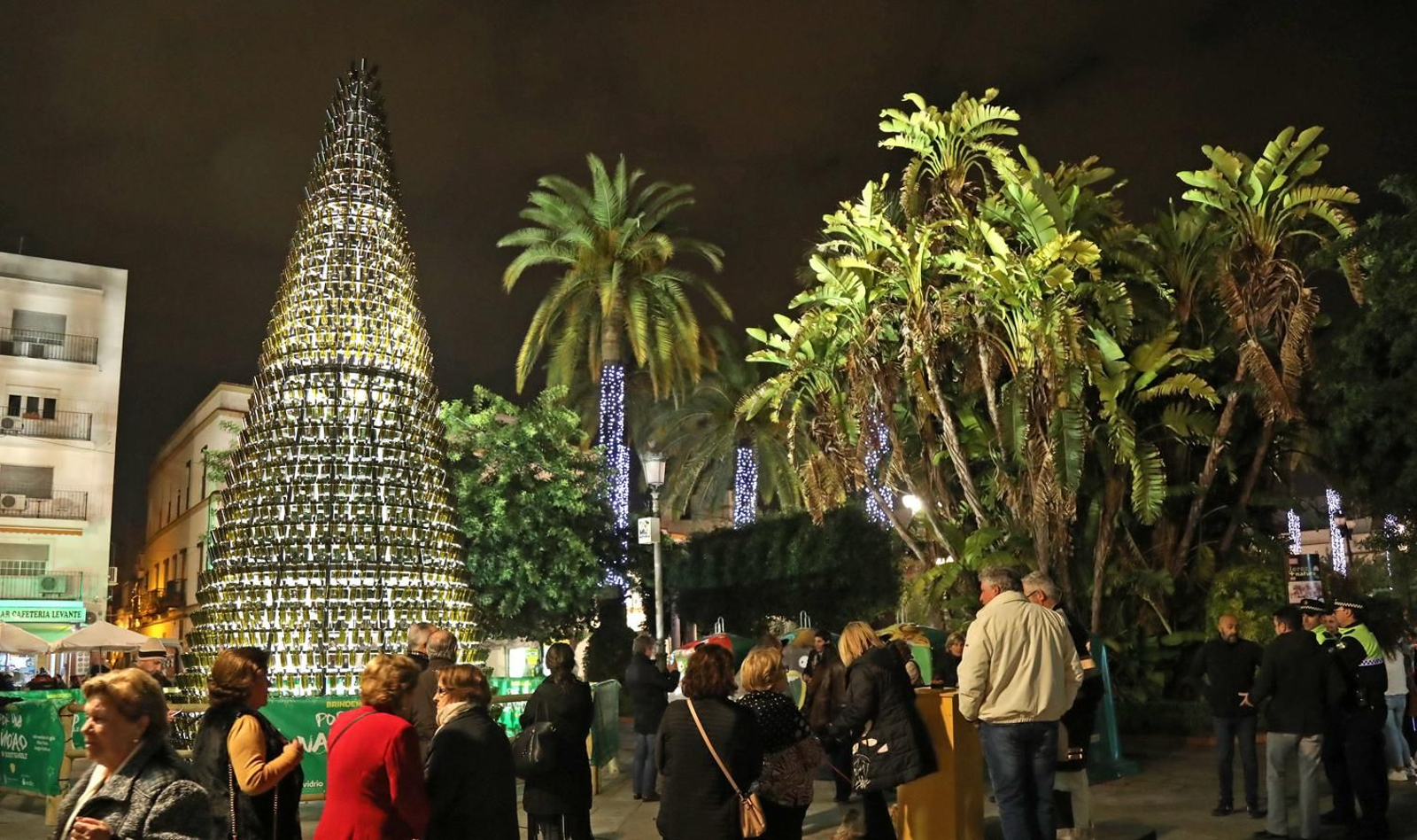 Un grupo de ciudadanos presencia el árbol de botellas de cristal. Un grupo de ciudadanos presencia el árbol de botellas de cristal.
