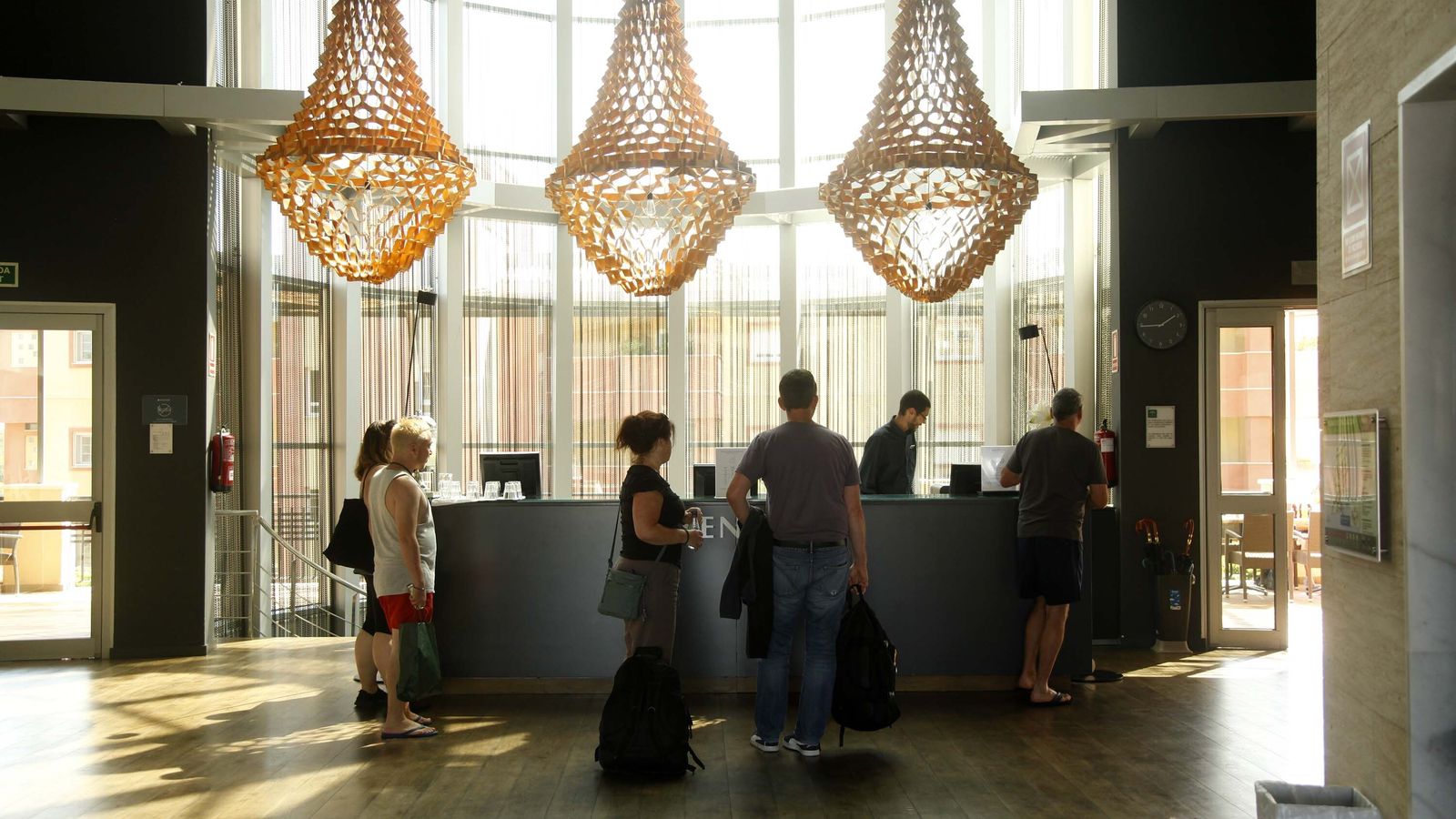 Turistas en la recepción de un hotel de la costa onubense