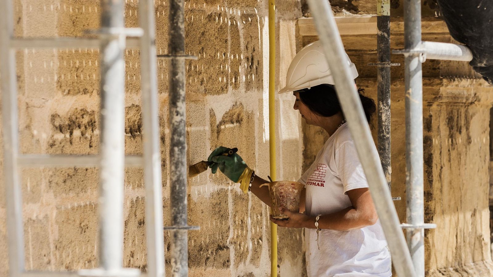 Una operaria interviniendo en la fachada del Palacio de Riquelme.