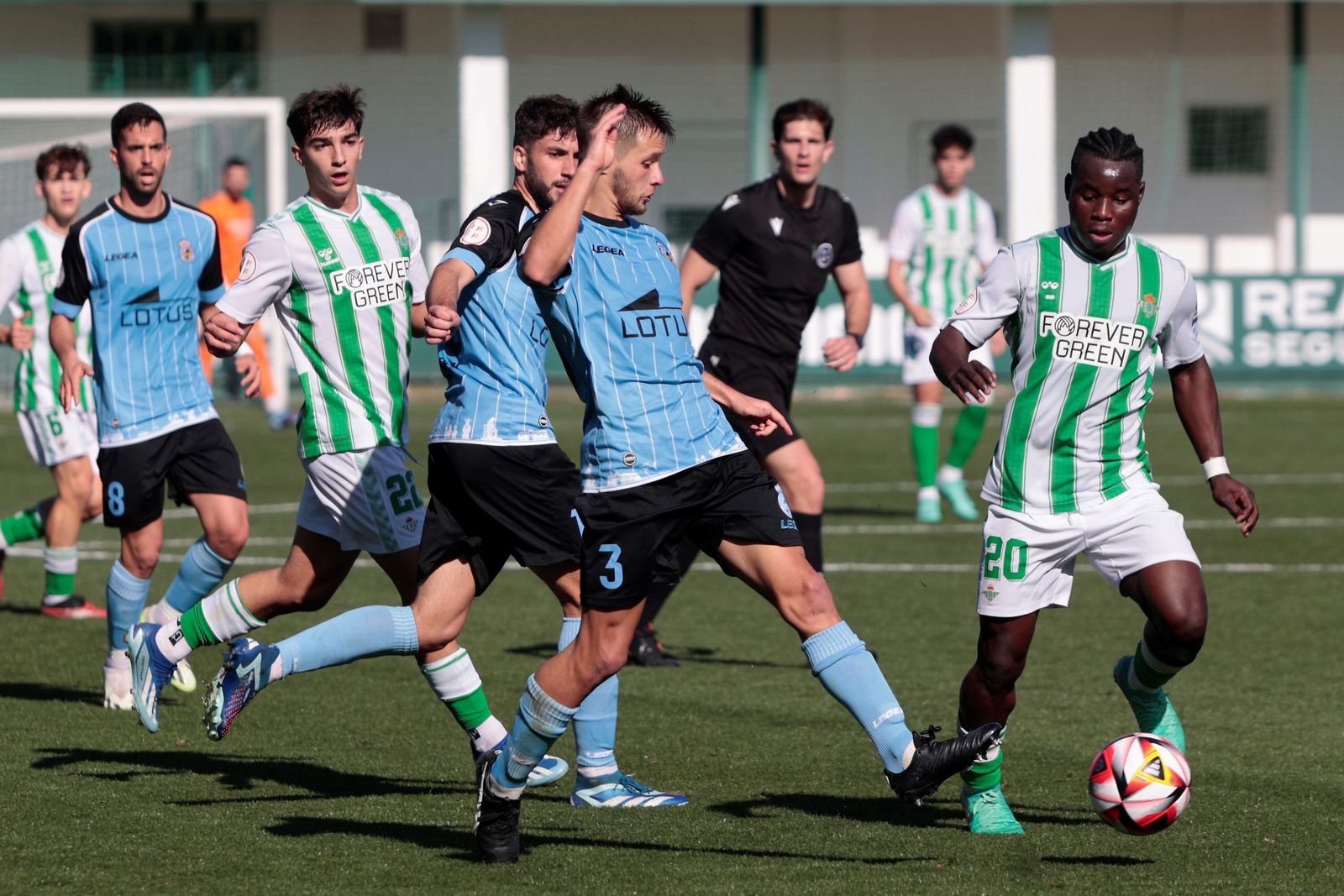 El bético Mawuli intenta evitar la entrada de un rival.