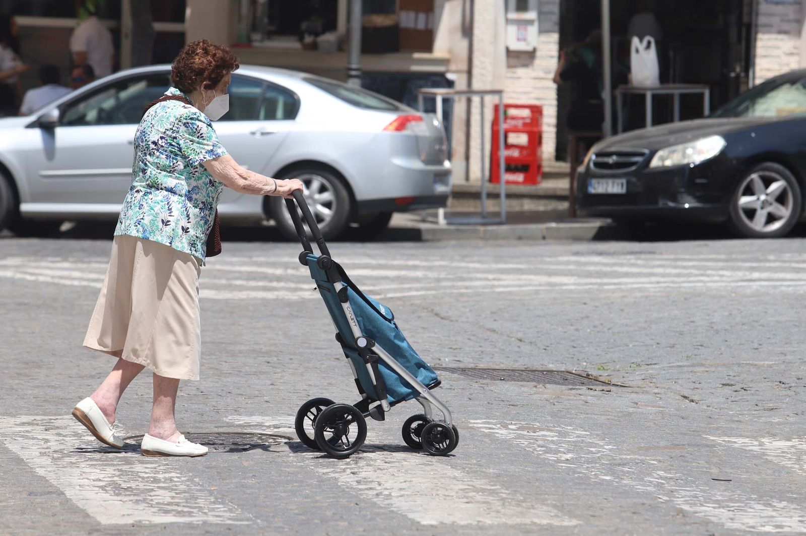 Una mujer pasea por Huelva con su mascarilla.