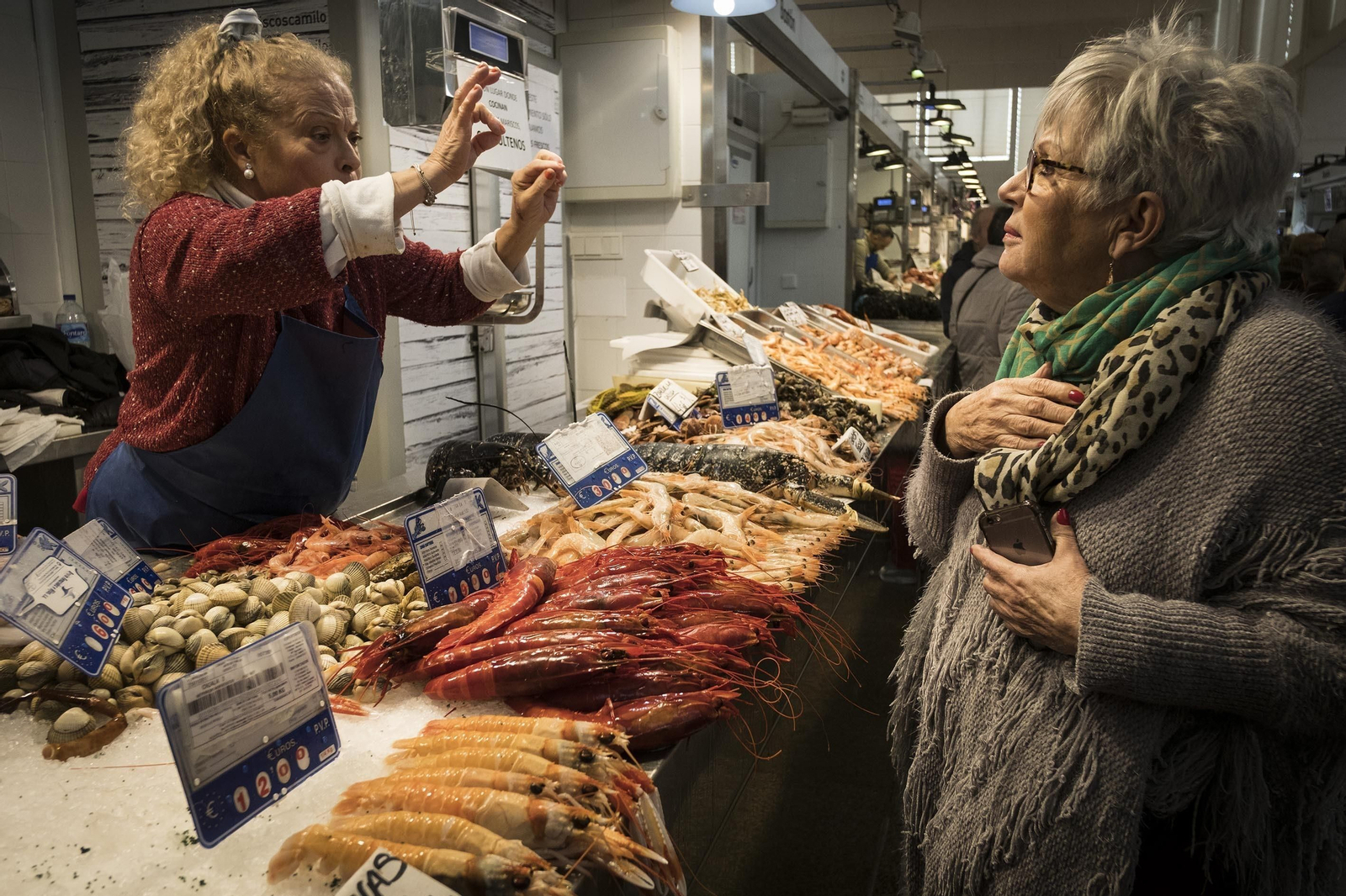 La propietaria de Mariscos Camilo, Catalina Bernal, atiende a una cliente en el día de ayer.