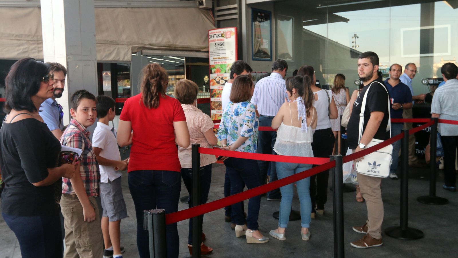 Un grupo de personas guardan cola en las taquillas de los multicines de El Tablero.