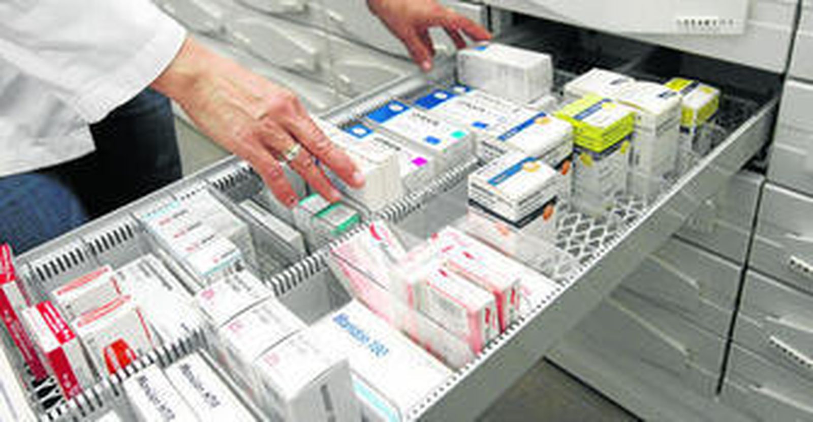 Un farmacéutico muestra uno de los cajones llenos de medicinas de la botica.