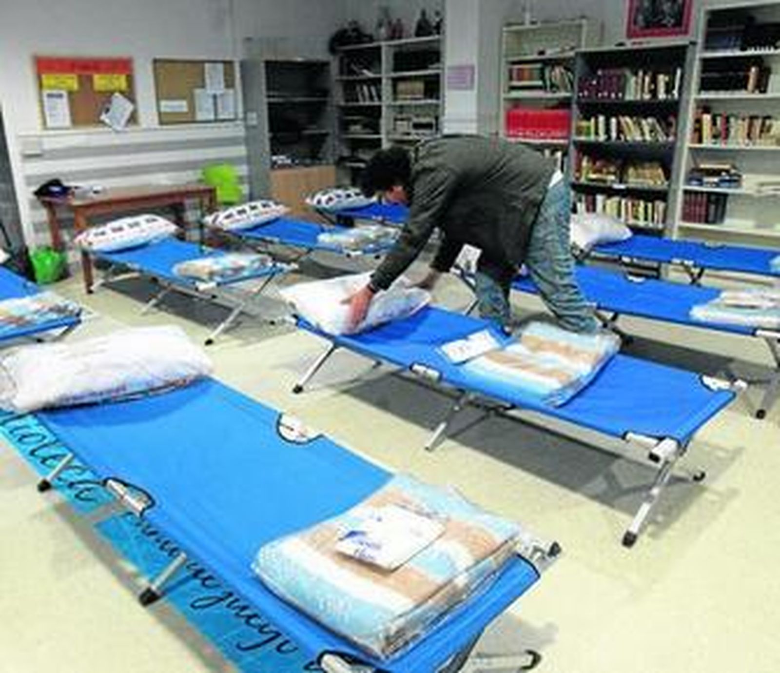 Un usuario prepara su cama de la campaña contra el frío en el Centro de Acogida Municipal.