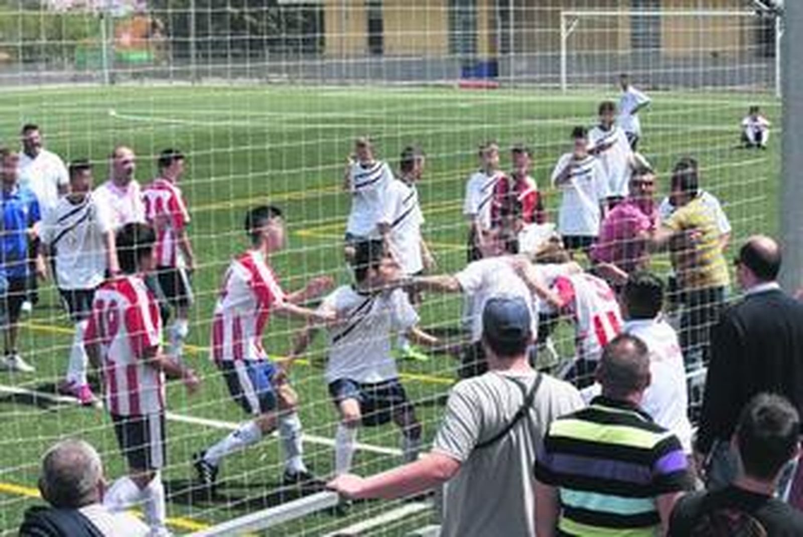El delegado del Juval protege a uno de los futbolistas que terminó siendo agredido.
