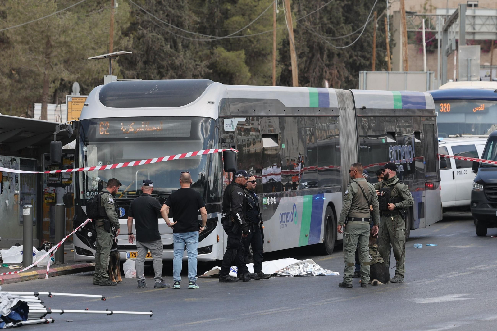 Agentes israelíes permanecen junto a un cuerpo en el lugar del tiroteo, en Jerusalén.
