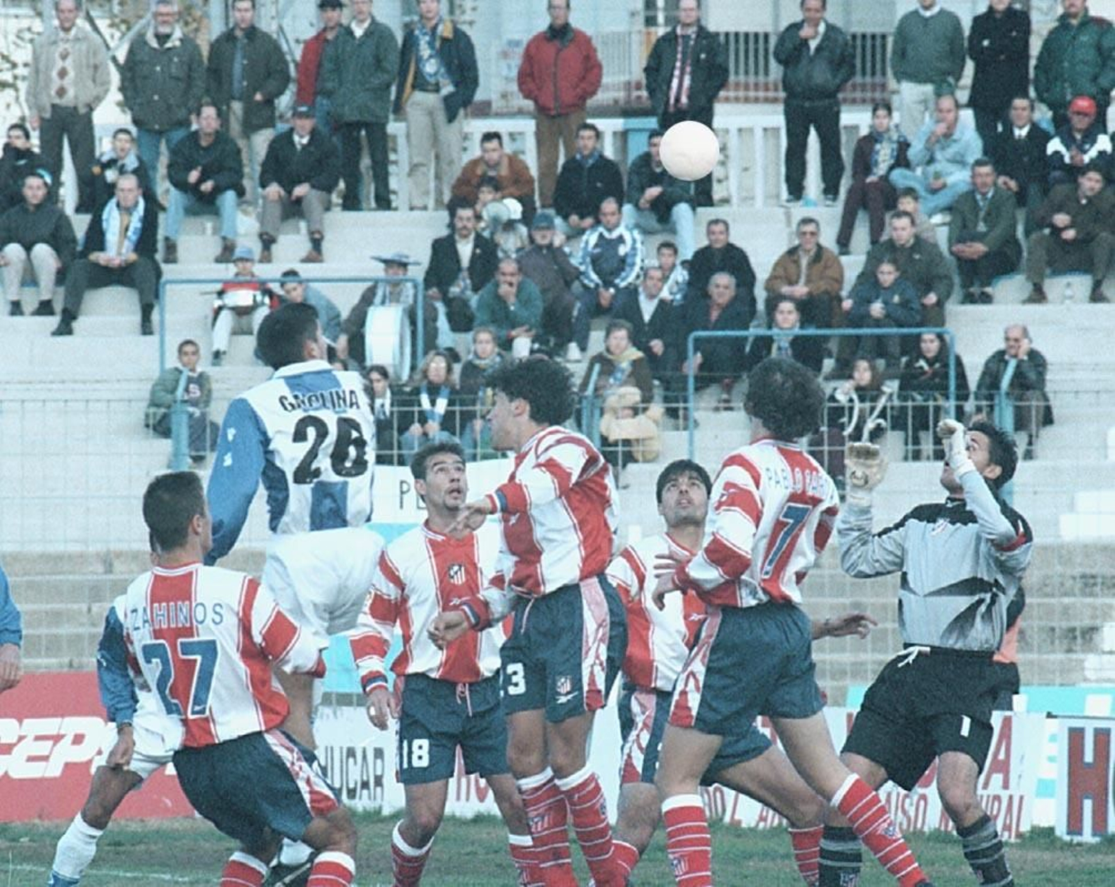 Gregorio Molina salta por un balón ante la presencia de varios jugadores del Atlético B