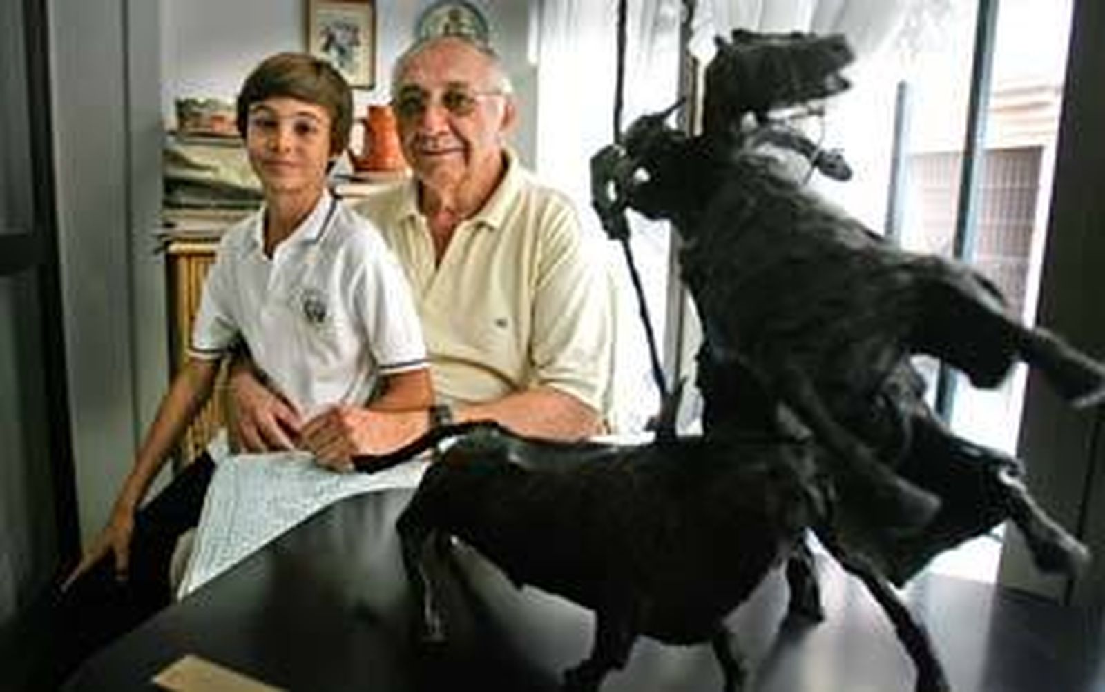 Alfonso Barroso, en un rincón de su casa, con su nieto Manuel, probable sucesor de esta dinastía taurina./Pascual