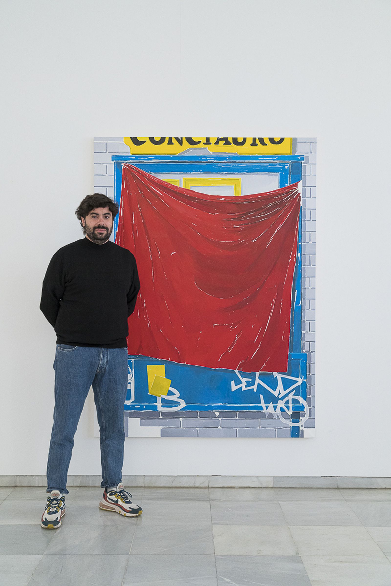 Andrés Aparicio junto a una de sus obras expuestas en 'Prohibido fijar carteles'