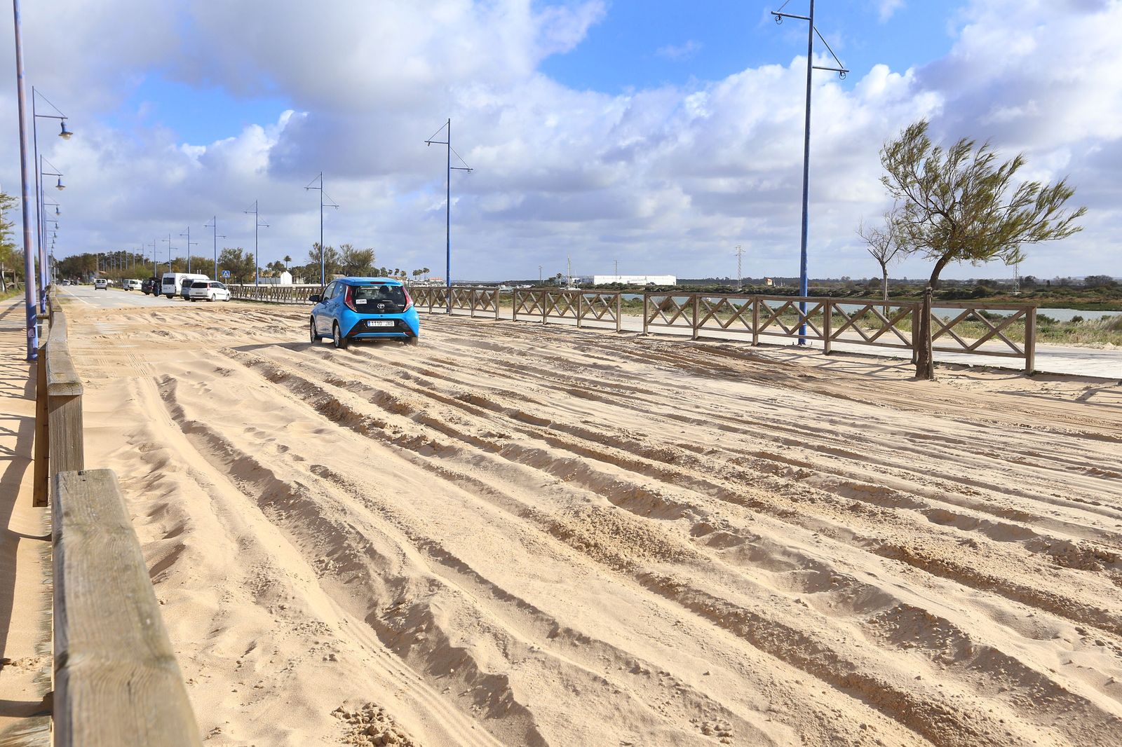 Un vehículo atraviesa con dificultad la zona afectada por la arena, ayer al mediodía.