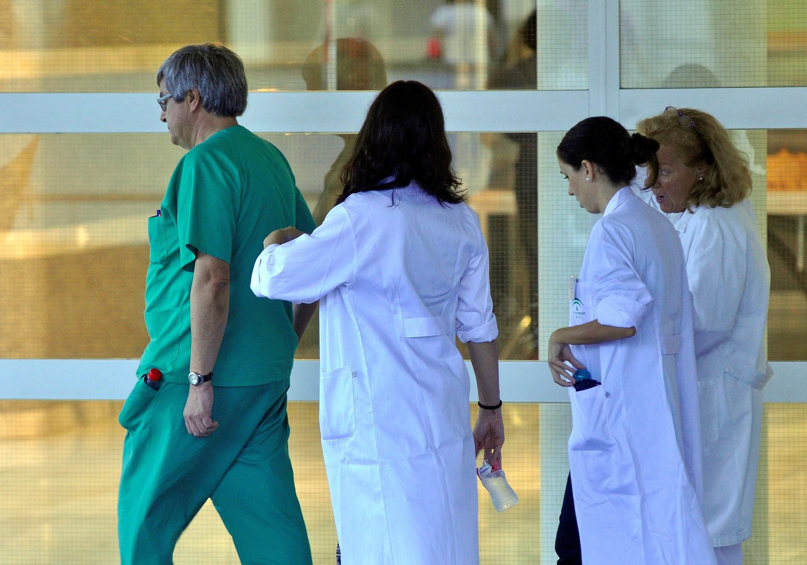 Varios médicos en la puerta de un hospital.