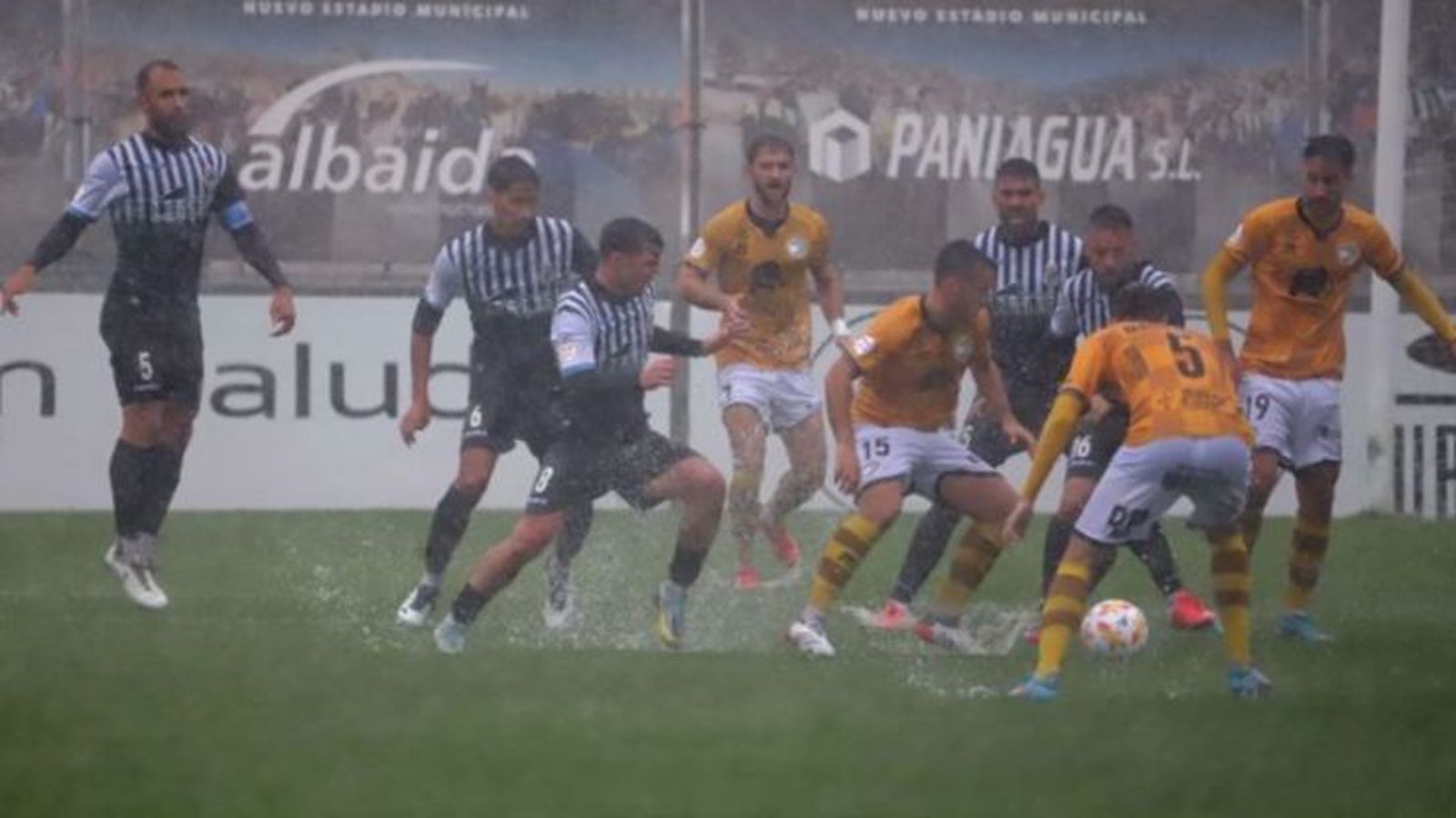 Jugadores de Balona y Unionistas, bajo una tromba de agua y sobre un terreno de juego más que encharcado