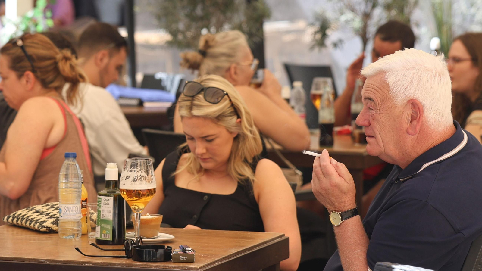 Un cliente fuma en una terraza de un establecimiento de hostelería en Málaga.