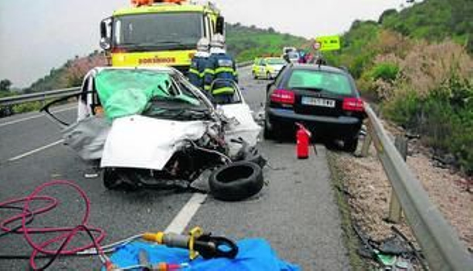 Miembros del cuerpo de Bomberos, junto a los vehículos accidentados en la carretera de Algodonales.