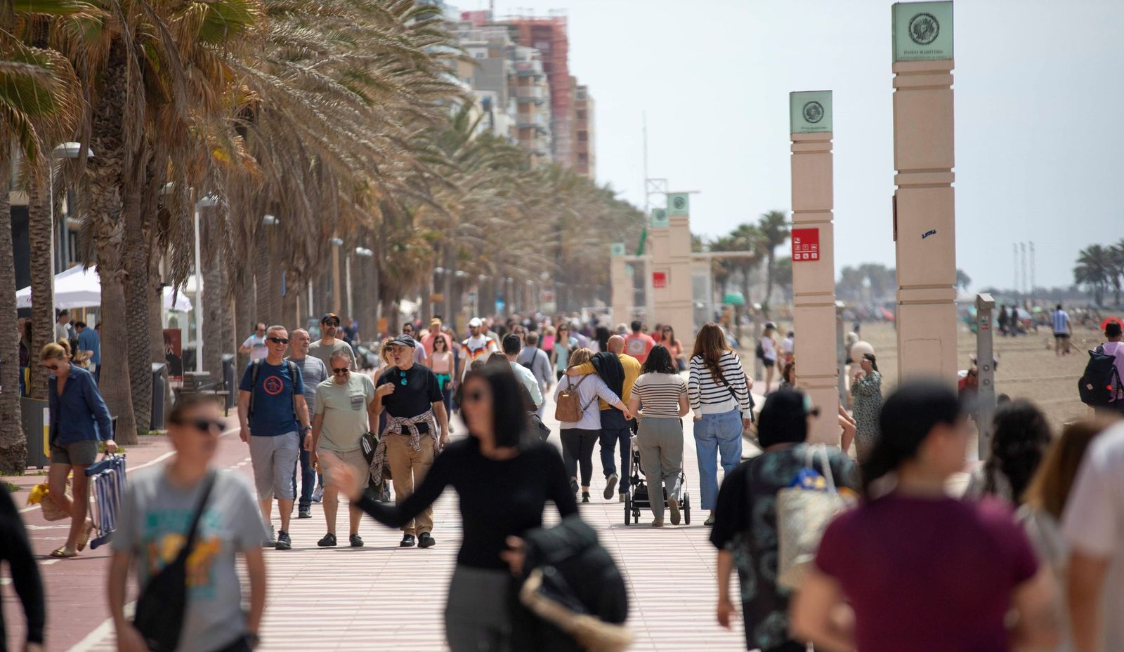 Un numeroso grupo de personas caminando por el Paseo Marítimo de Almería.
