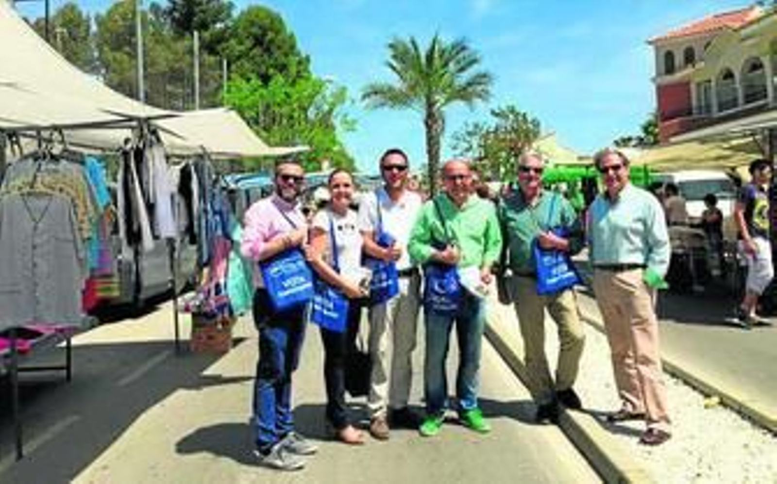 Miembros de la candidatura del PP en el mercadillo, dispuestos a repartir la propaganda electoral.