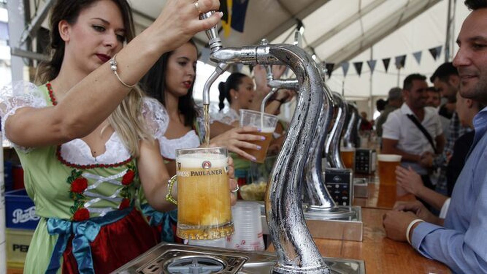 Jóvenes sirven cervezas en una de las barras de una edición pasada.