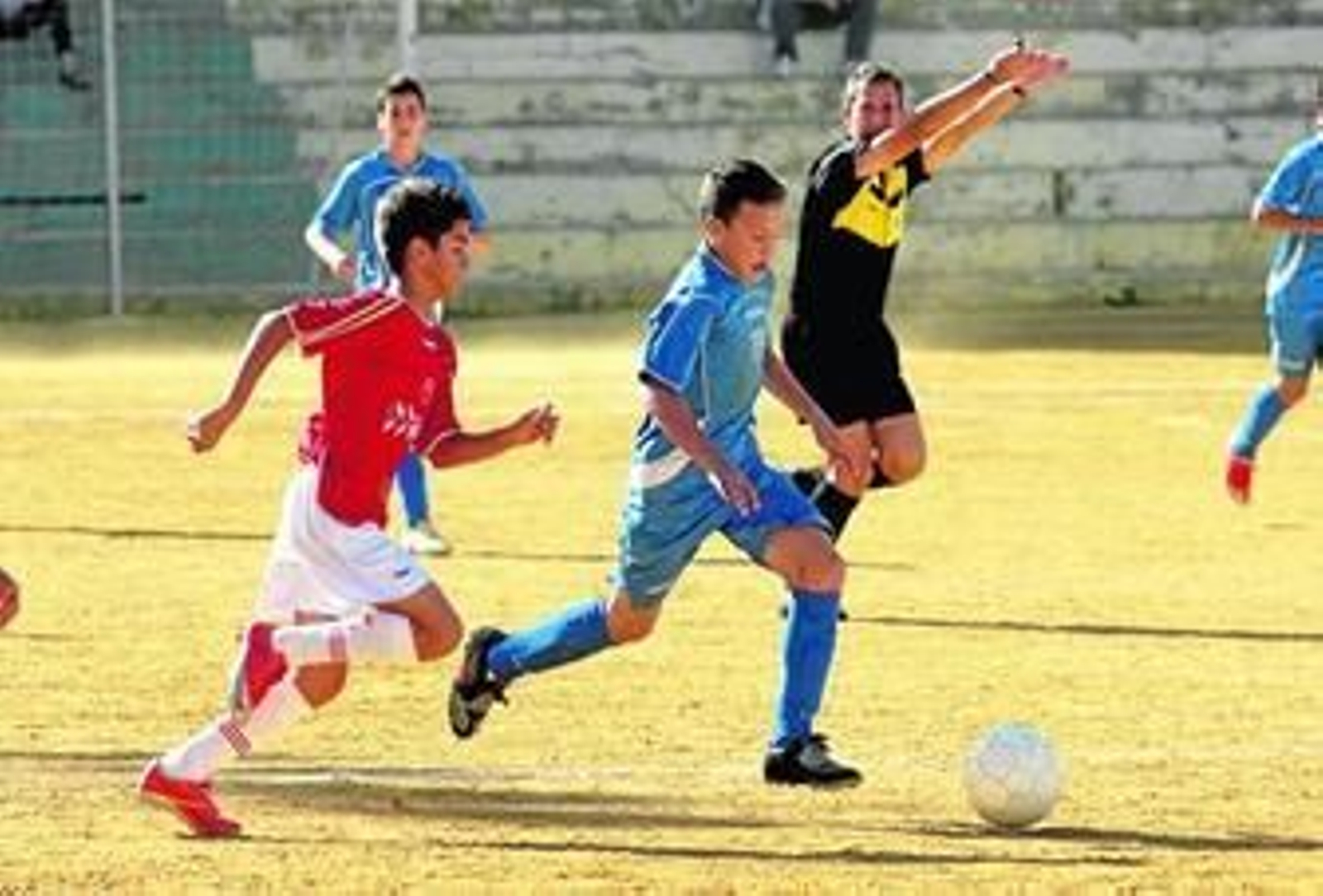 Un jugador del Puerto conduce el balón ante la llegada de dos jugadores del Granada 74. Un jugador del Puerto conduce el balón ante la llegada de dos jugadores del Granada 74.