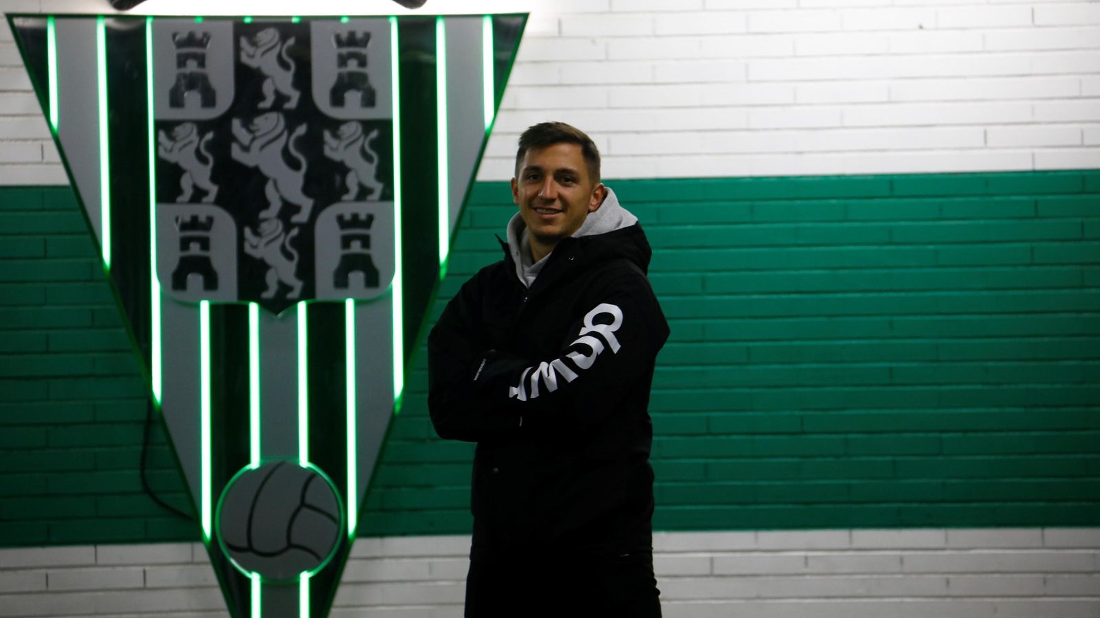 Christian Carracedo posa junto al escudo del Córdoba CF.