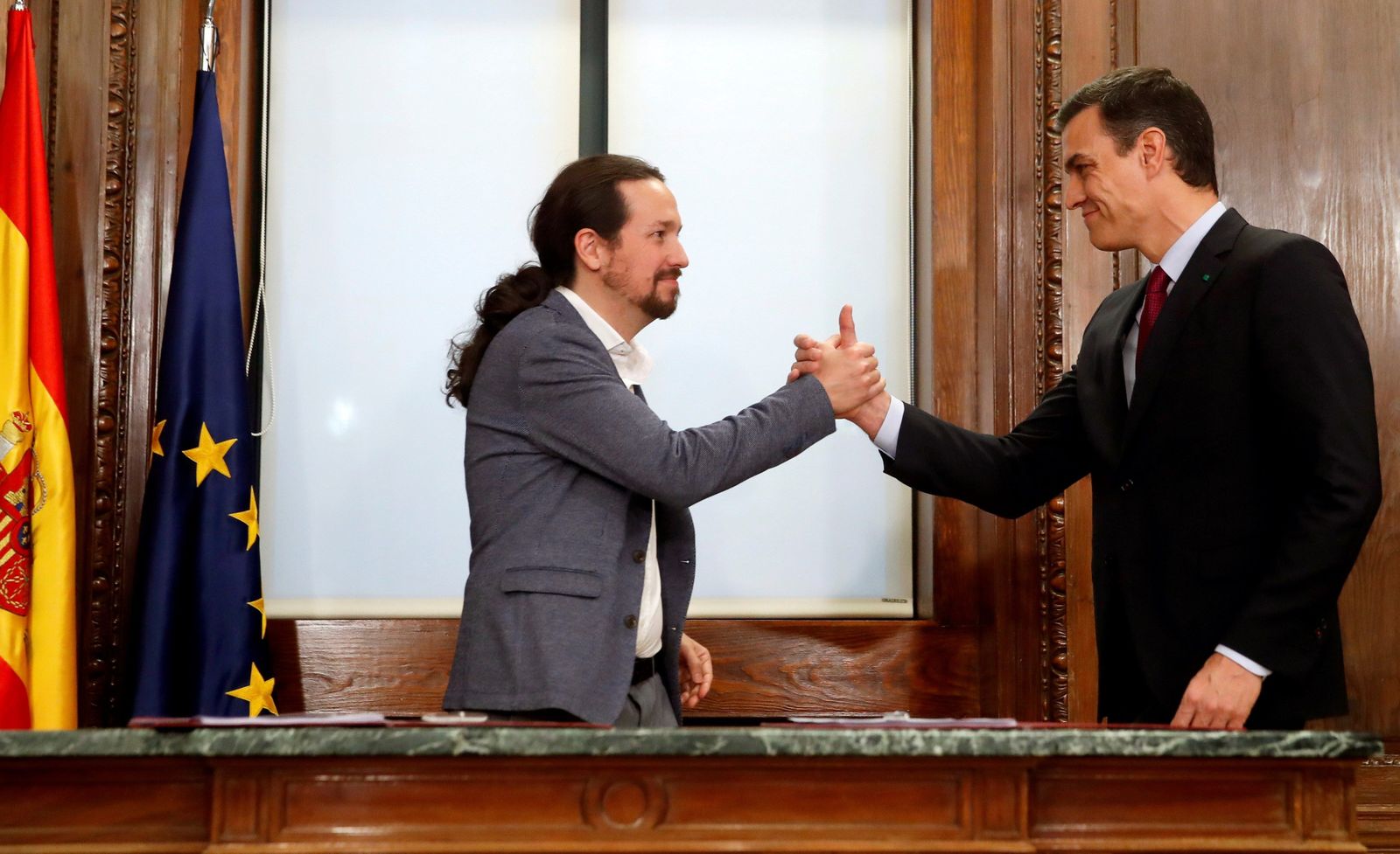 Pedro Sánchez y Pablo Iglesias estrechan sus manos tras el acto de firma del acuerdo programático en diciembre de 2019.