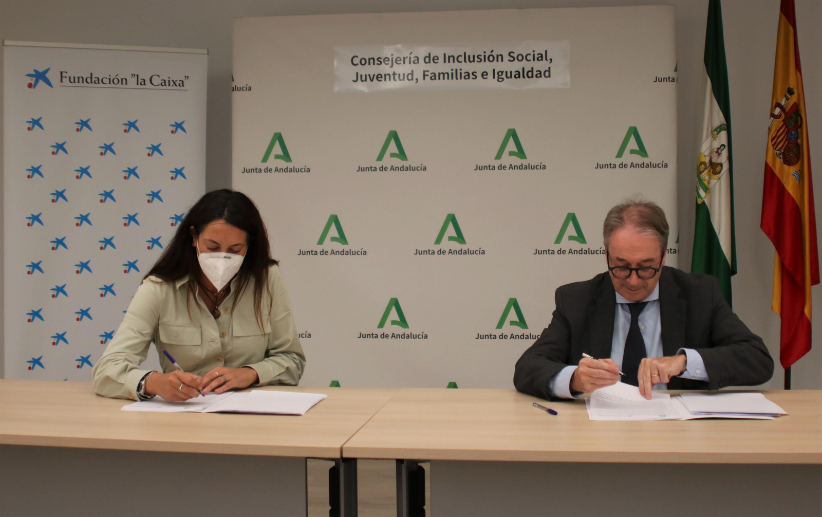 La consejera de Inclusión Social, Loles López, y el subdirector general de la Fundación la Caixa, Marc Simón, firman el convenio.