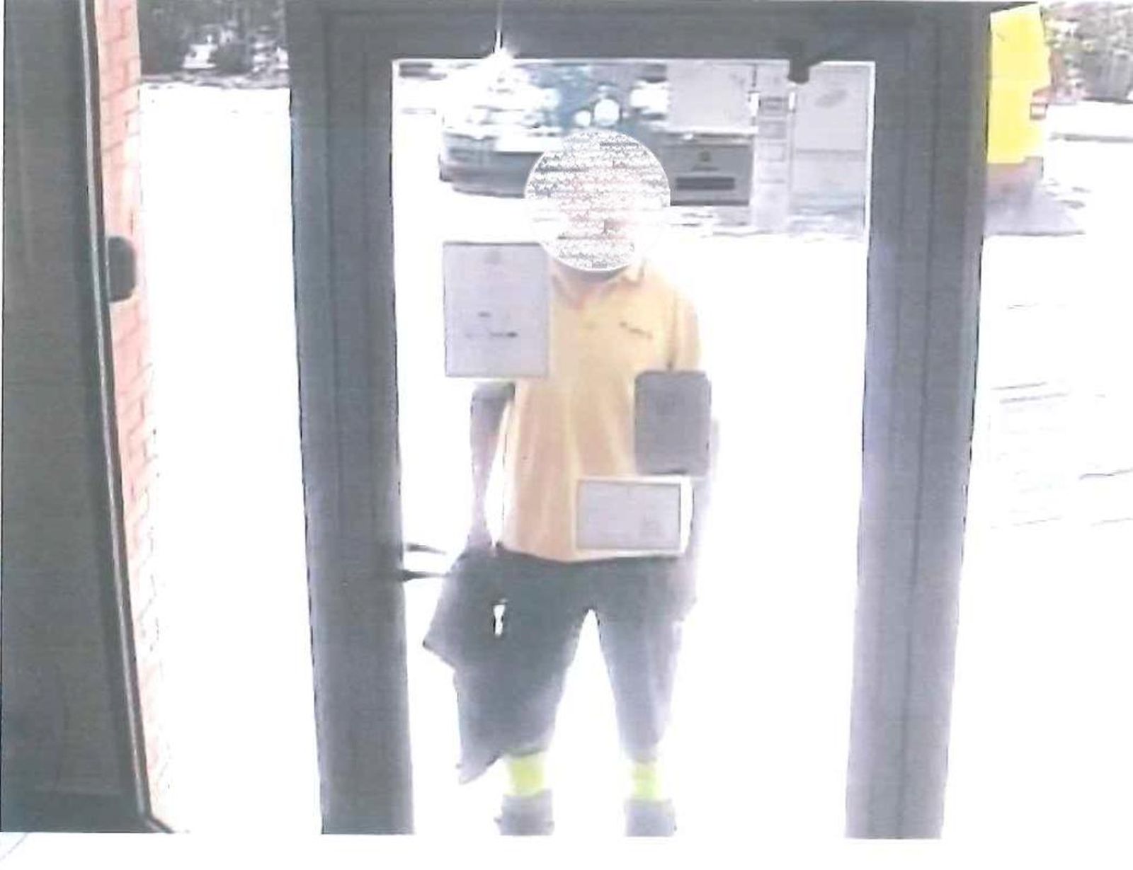 Uno de los atracadores a las puertas de la oficina de correos donde se cometió el robo.