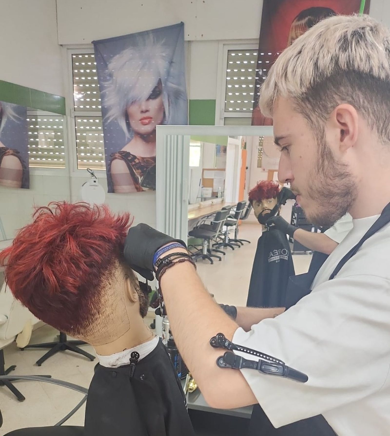 Antonio Gómez Calderón con un maniquí practicando peinados y cortes de pelo.