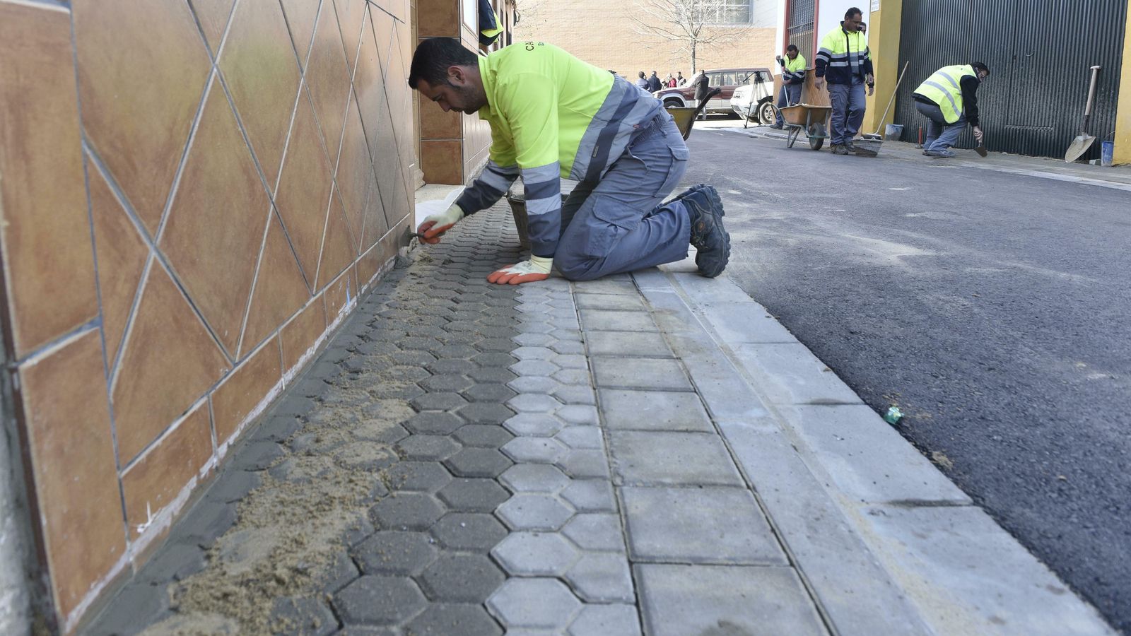 Trabajos de remates en las aceras de Palmete en una calle con plataforma única.