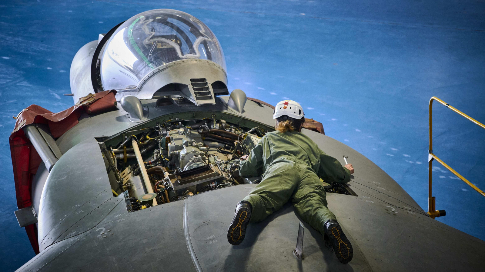 Técnicos de mantenimiento de la Armada en plena faena de reparación o revisión de los Harriers.