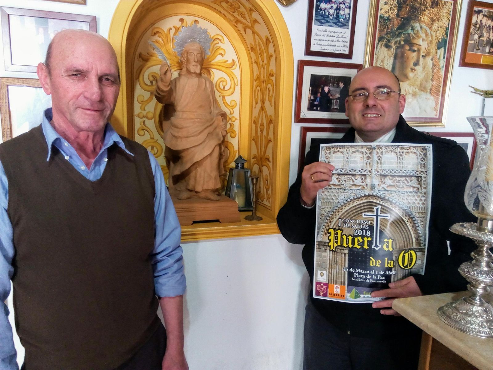 El presidente del Rincón del Costalero, mostrando el cartel anunciador junto al hostelero organizador del certamen.