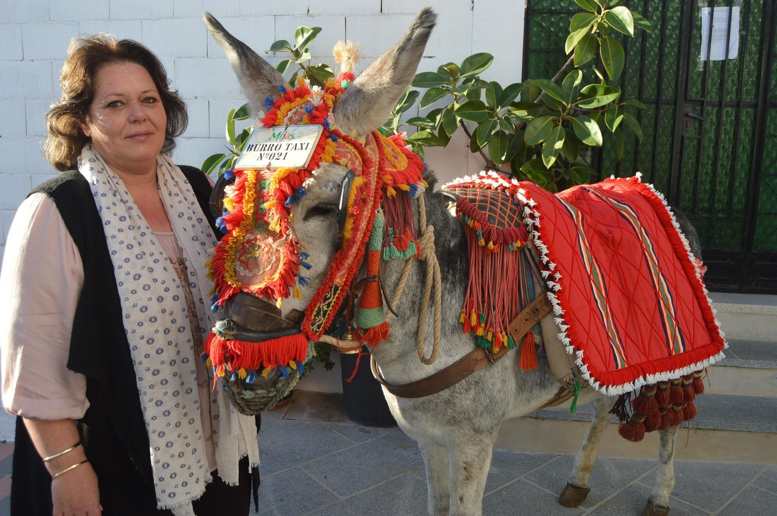 Lourdes Díaz, artesana talabartera, junto a uno de sus burros.