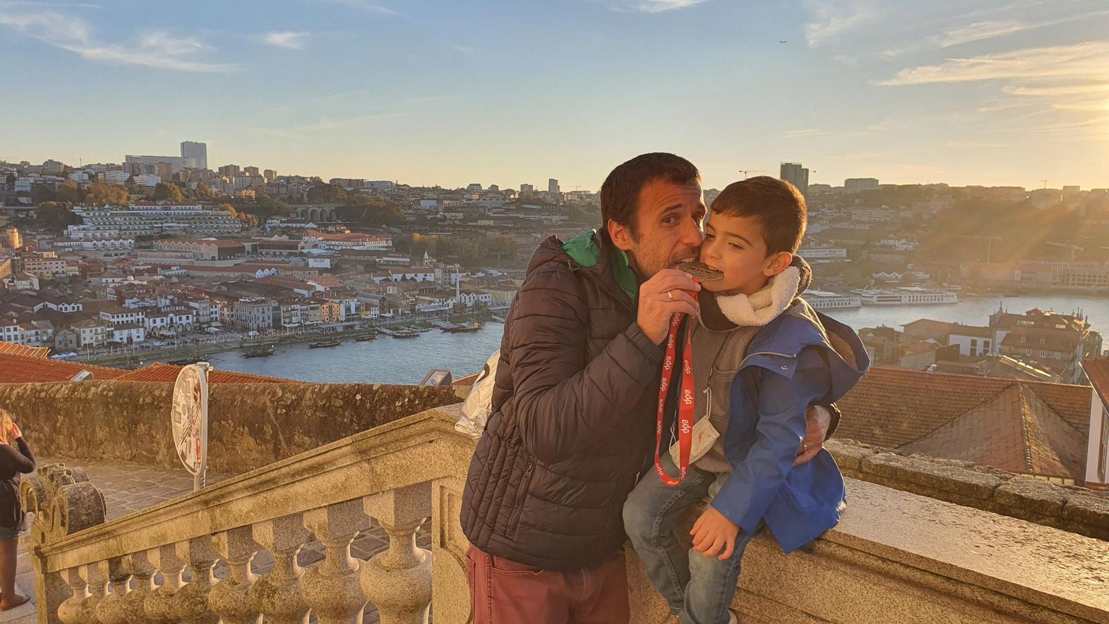 Con el pequeño Mario, mordiendo la medalla con una vista de Oporto desde la Catedral.